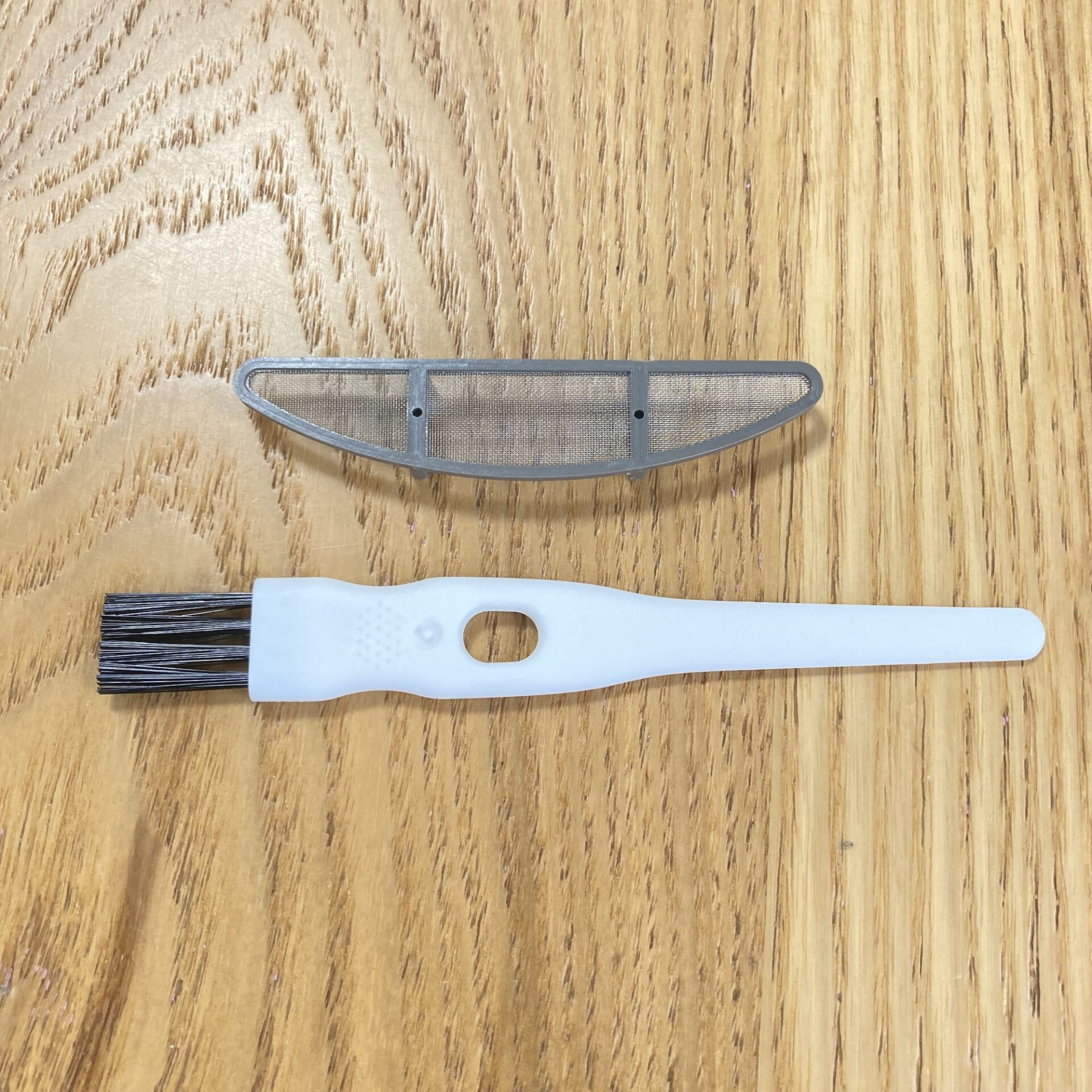 集塵ケースとクリーニングブラシの写真