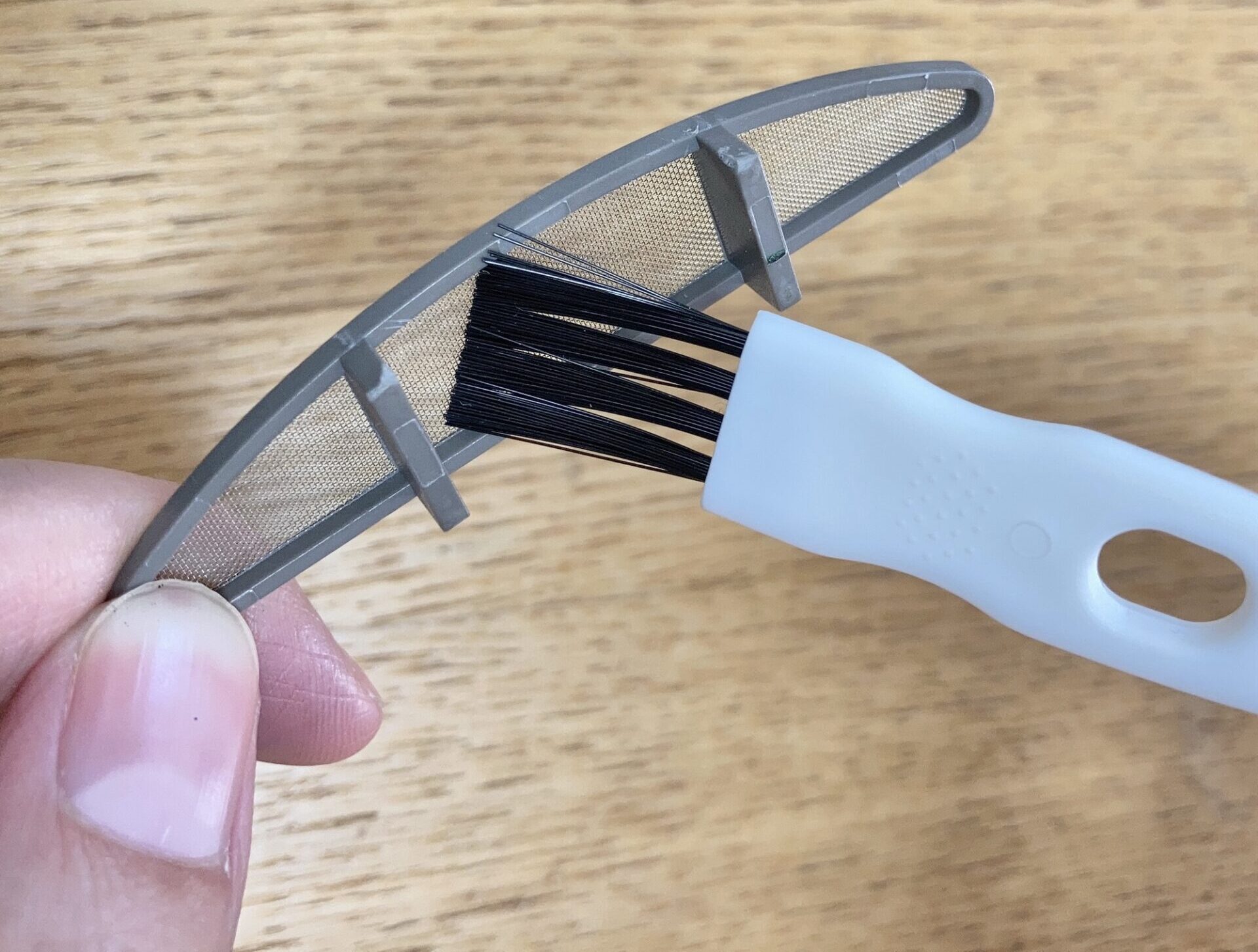 集塵ケースをクリーニングブラシでお手入れしている様子