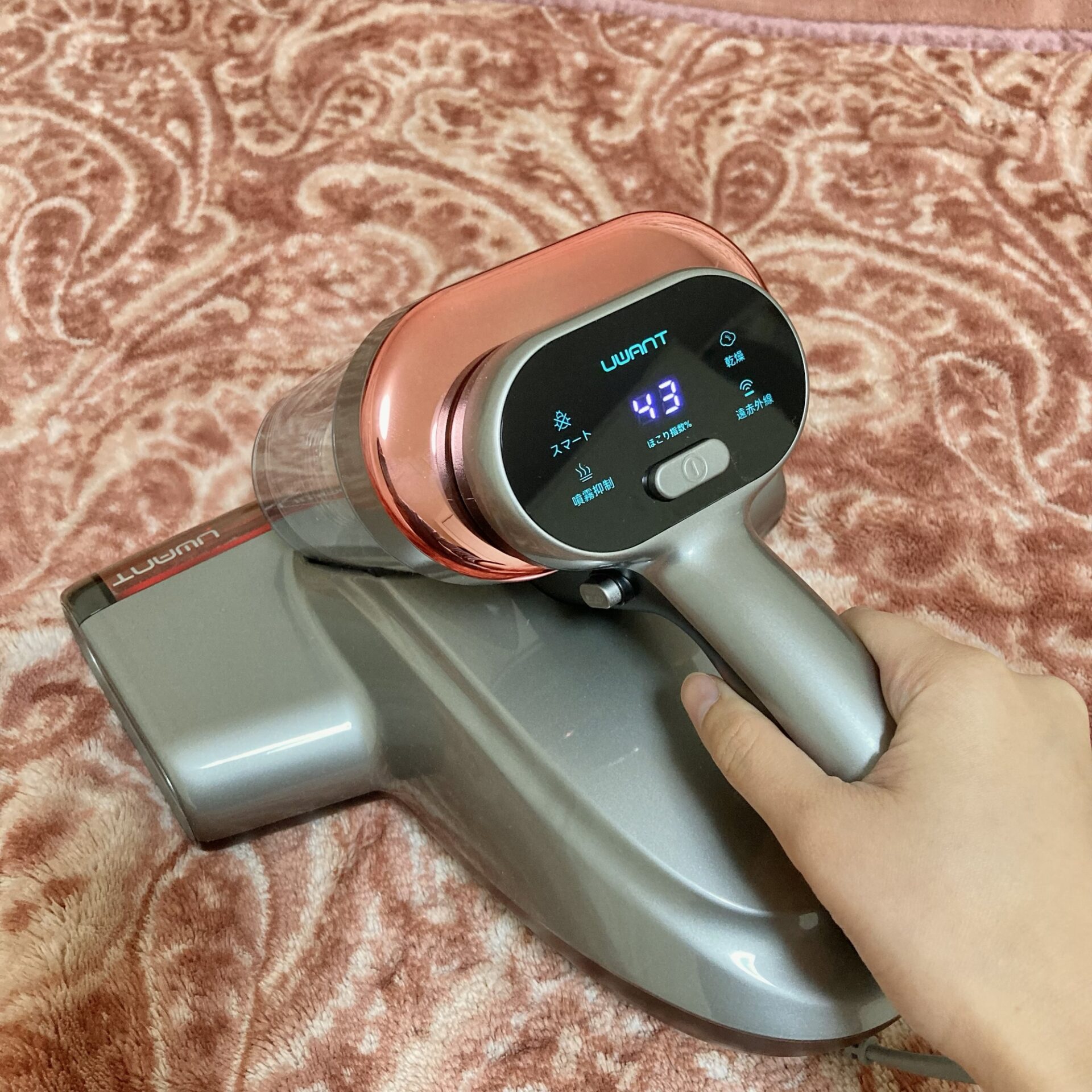 毛布の上でUWANT M700布団クリーナーを使っている様子の写真